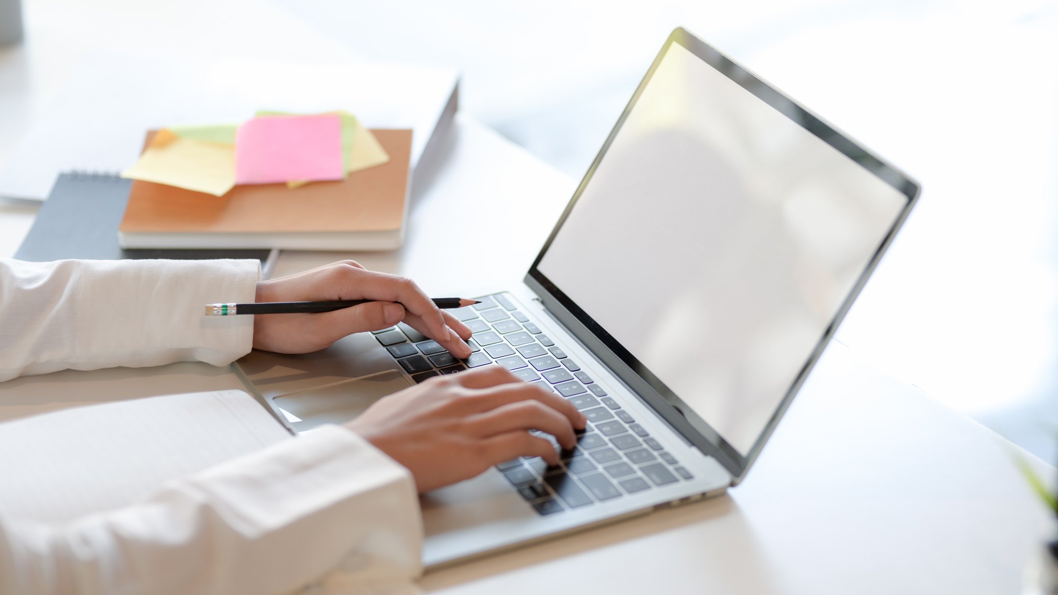 Crop woman working on laptop in office