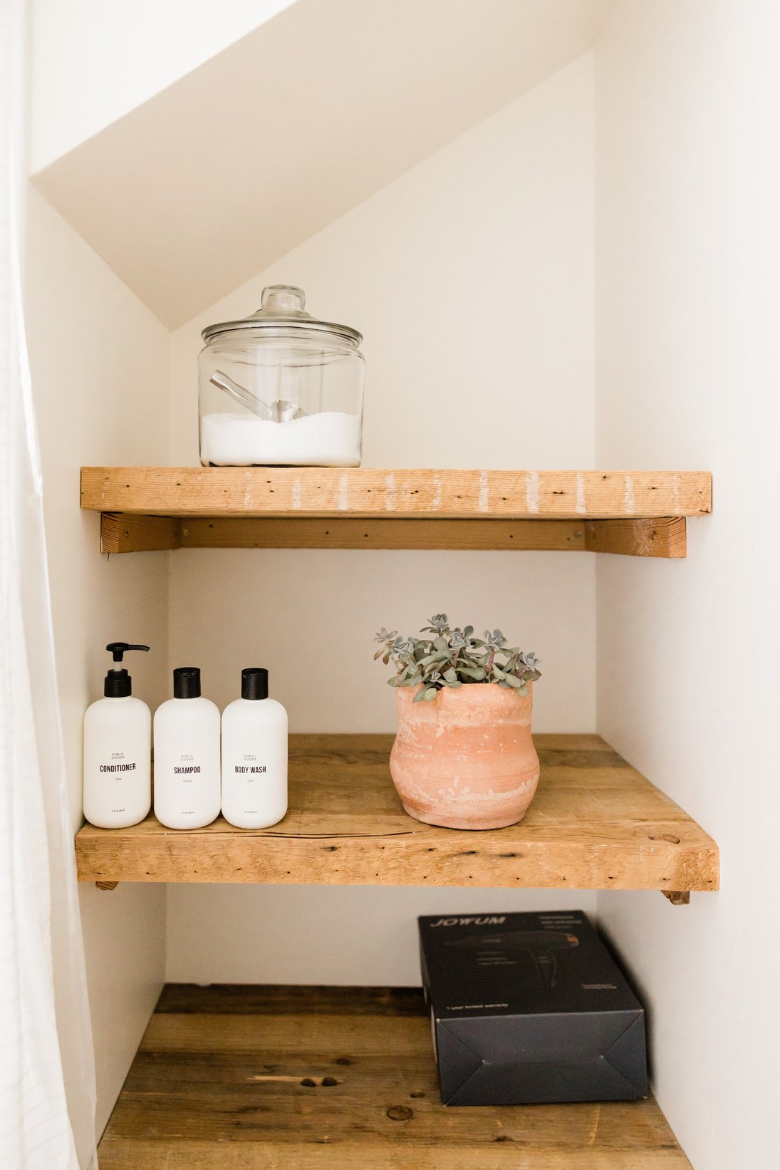 Bottles of Toiletries and Decors on Bathroom Shelves